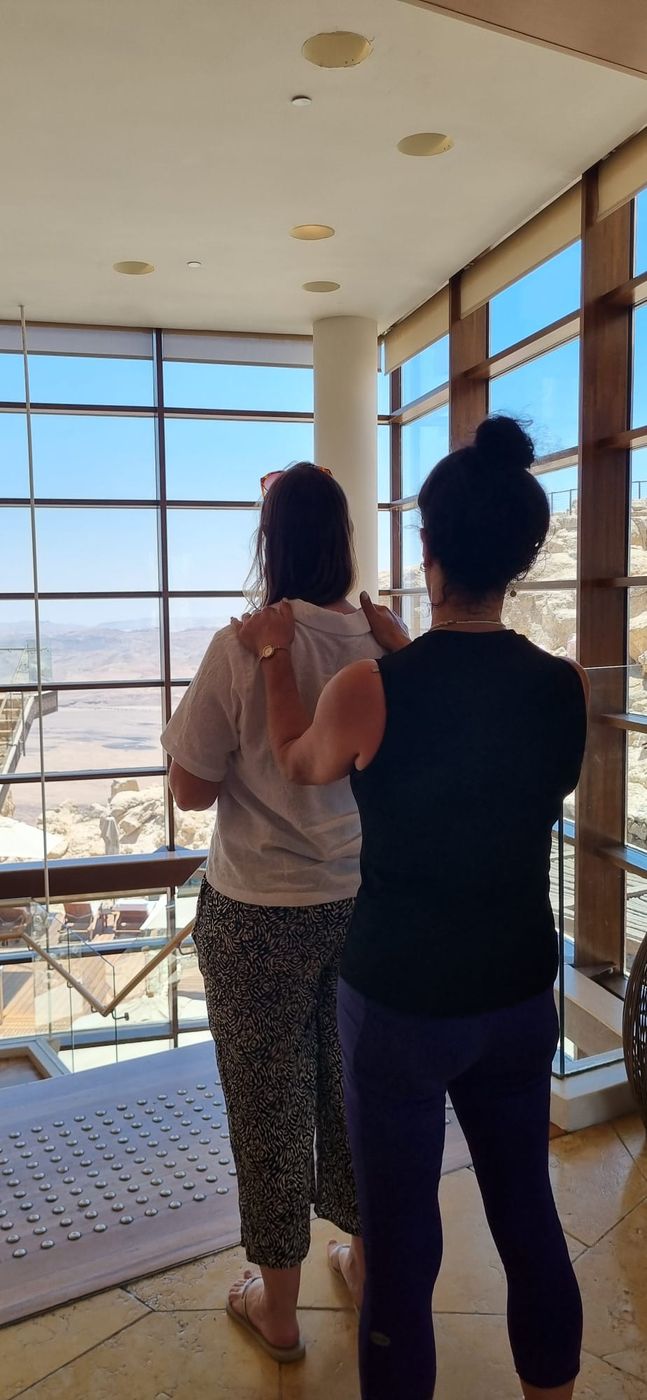 מטפלת מובילה משתתפת בתרגיל מוביל ומובל מול נוף המכתש
